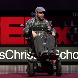 Travis Amick TEDx Talk - Travis in a wheel chair on stage