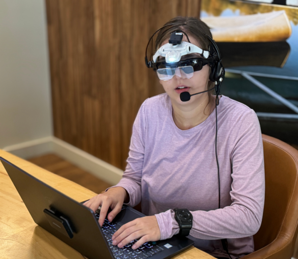 Dani wearing the VISORS prototype while typing on a laptop